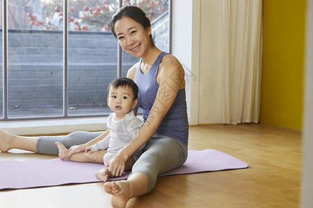 年轻妈妈带着宝宝居家运动图片