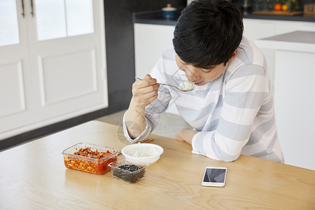 餐桌上吃饭的青年男子图片