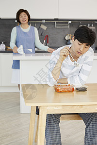 洗牌独自坐在餐桌上吃饭的男青年背景
