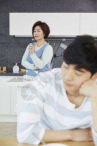 厨房里的母亲不满的看着儿子图片
