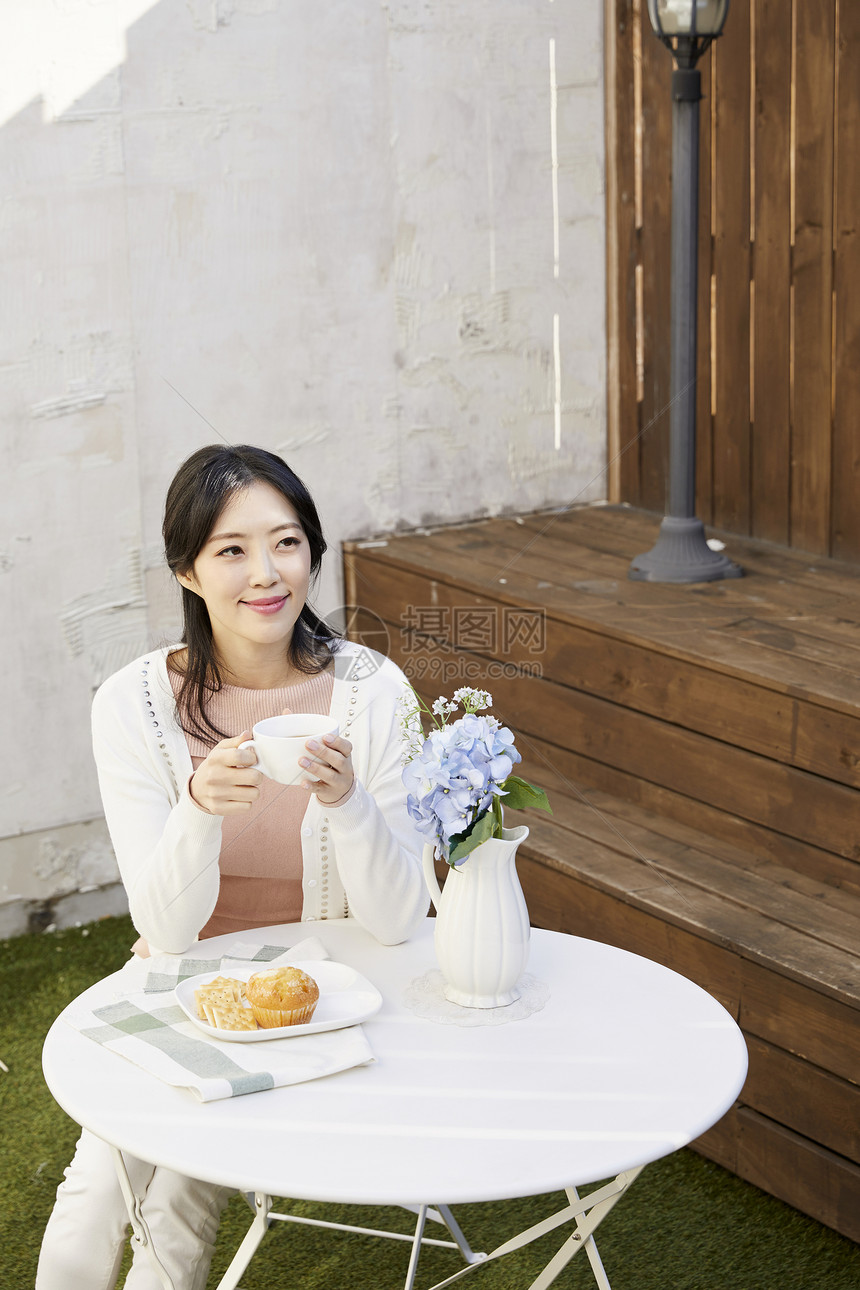户外喝下午茶的年轻女子图片
