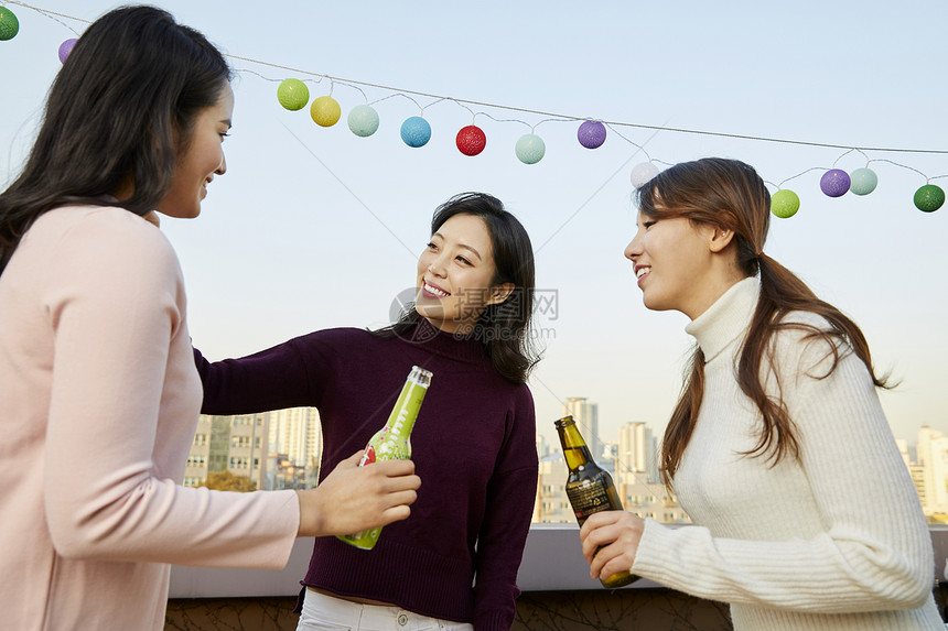 屋顶天台上聚会干杯的年轻女人们图片