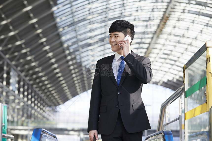 商务男青年在机场出差打电话图片