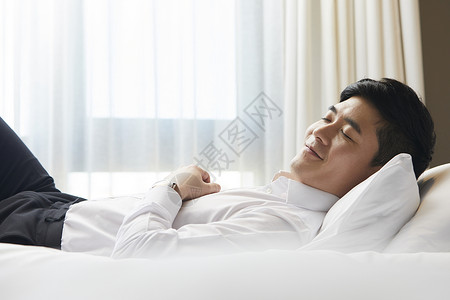 商务男青年出差在酒店休息图片