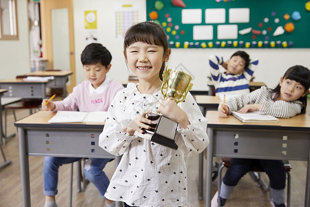 小女孩在学校得奖杯图片