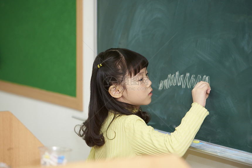 小学生在黑板上画画图片