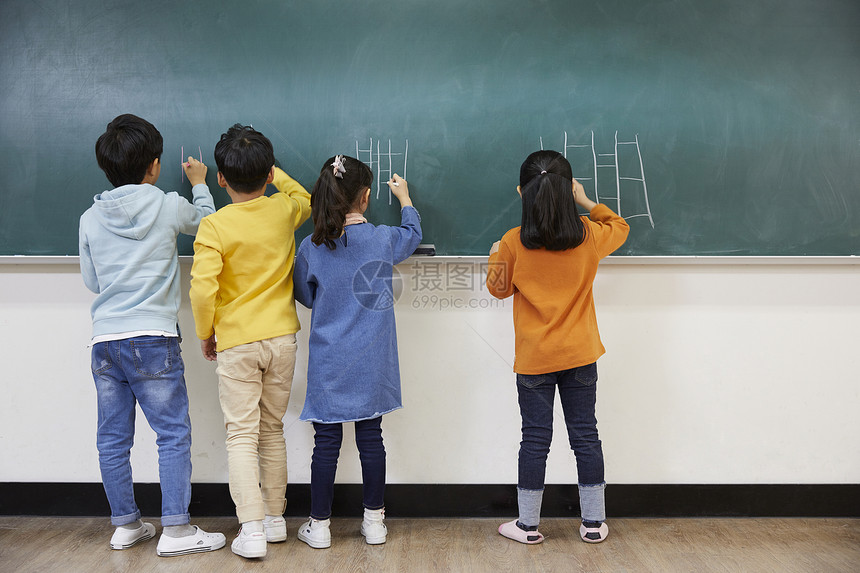 在黑板上写字的小学生图片