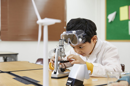 男孩在用显微镜做实验图片
