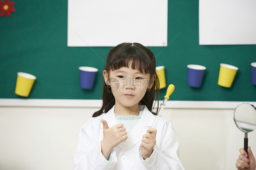 实验课堂上小女孩拿着实验仪器图片