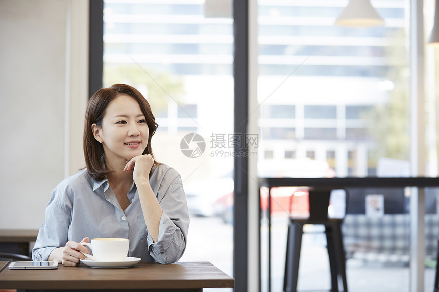 坐在咖啡馆休息喝咖啡的女青年图片