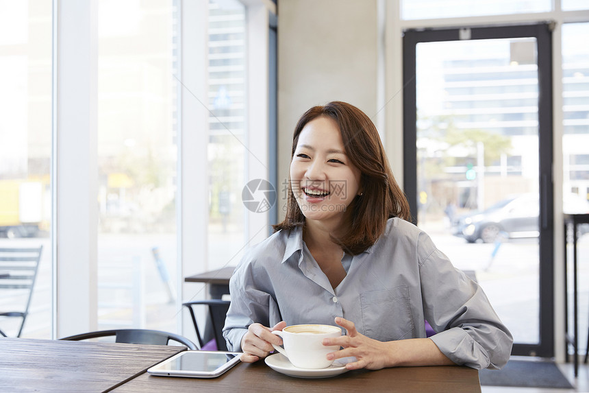 咖啡馆喝咖啡微笑的女青年图片