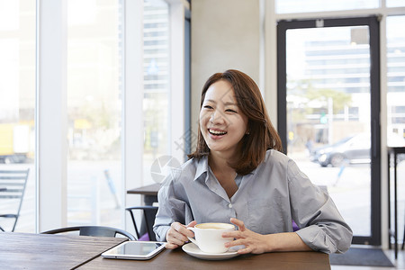 咖啡馆喝咖啡微笑的女青年图片