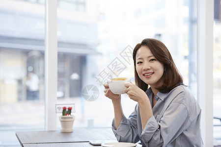 咖啡馆里喝咖啡的年轻女子图片