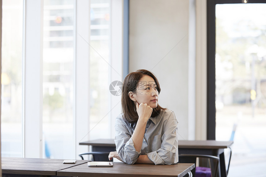 坐在咖啡馆里的年轻女子图片