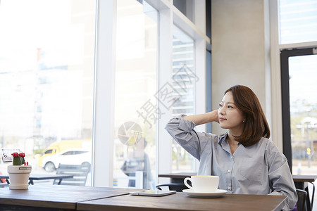 咖啡馆休息的年轻女子高清图片