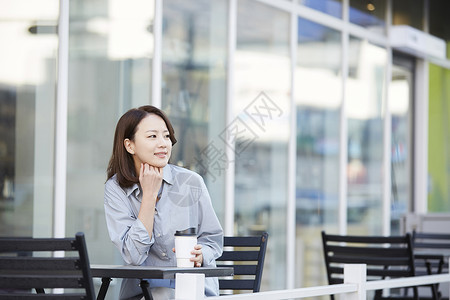 室外露天咖啡厅喝咖啡的成年女子图片