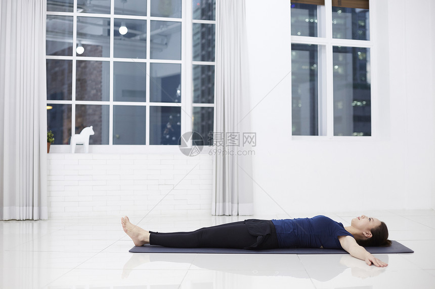 躺在瑜伽垫上休息的成年女子图片
