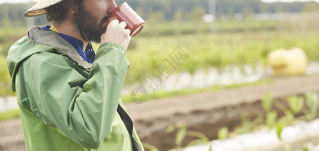 拿着水杯喝水的男性图片