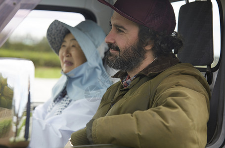 原野开车旅客座椅驾驶卡车的外国人和农夫妇女图片