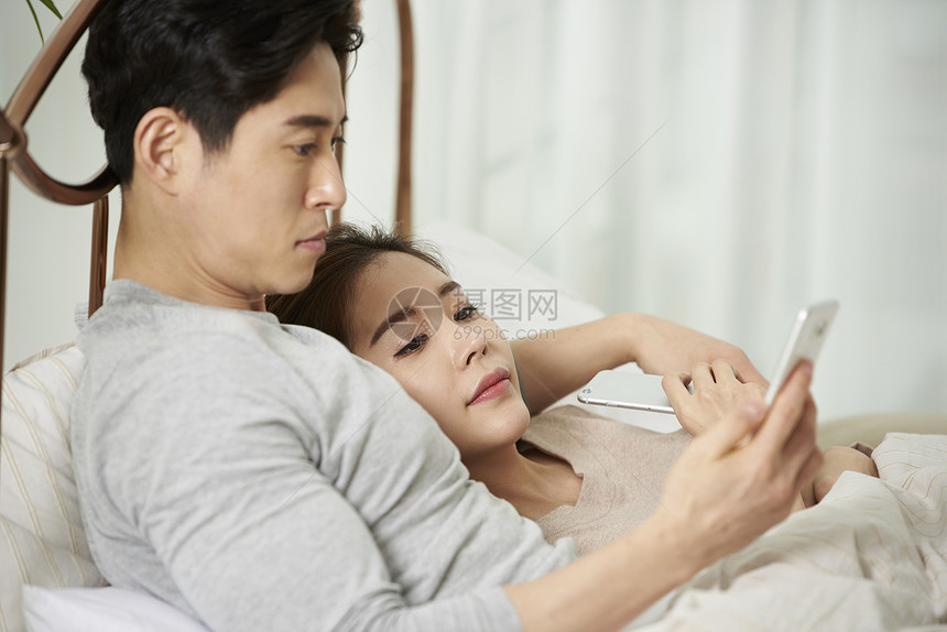 躺在床上的夫妇看手机图片