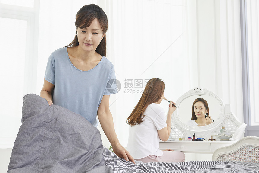 妈妈整理床铺女儿化妆图片