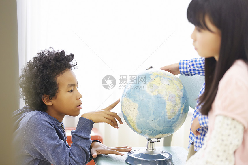 国际学校小学生看着地球仪图片
