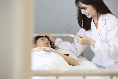 校医关怀躺在保健室床上的小学生背景
