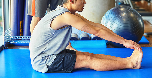 锻炼肌肉客人室内在健身房锻炼的男人和教练图片
