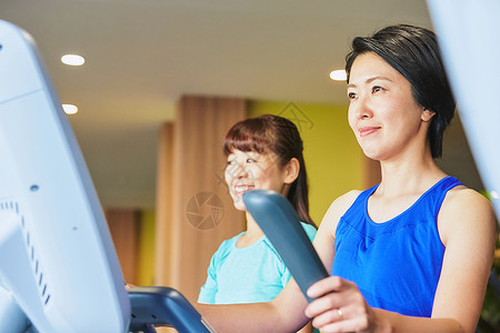 积极跑步机机器在健身房锻炼的妇女图片