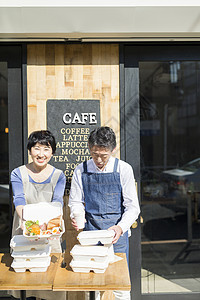 男人笑脸男子卖午餐盒食物事务的已婚夫妇图片