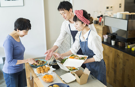 20多岁员工女士卖午餐盒食物事务的已婚夫妇图片