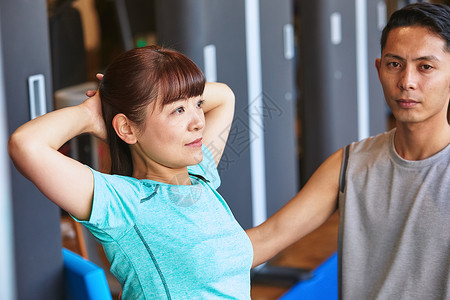 新鲜室内亚洲行使在健身房的妇女和教练员背景图片