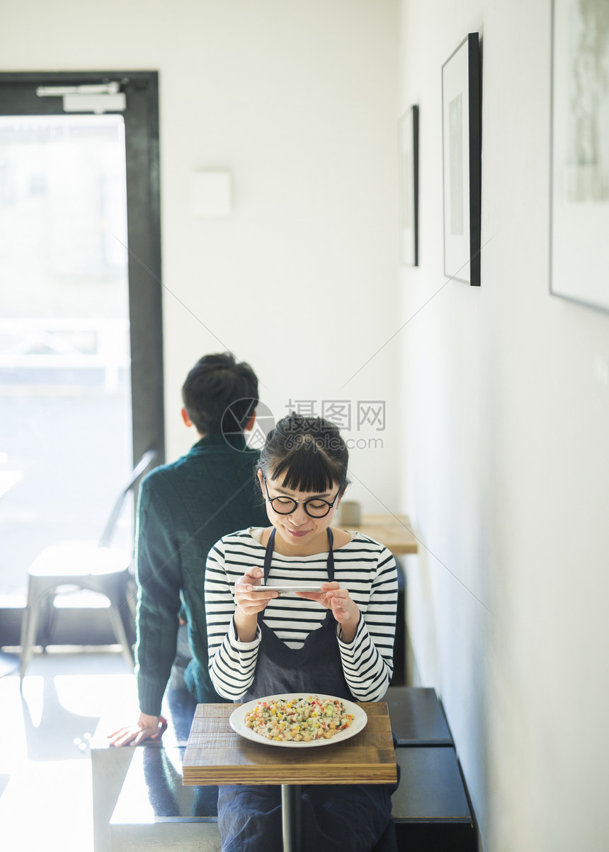 商务手机时髦工作在咖啡馆休息食物事务的妇女图片