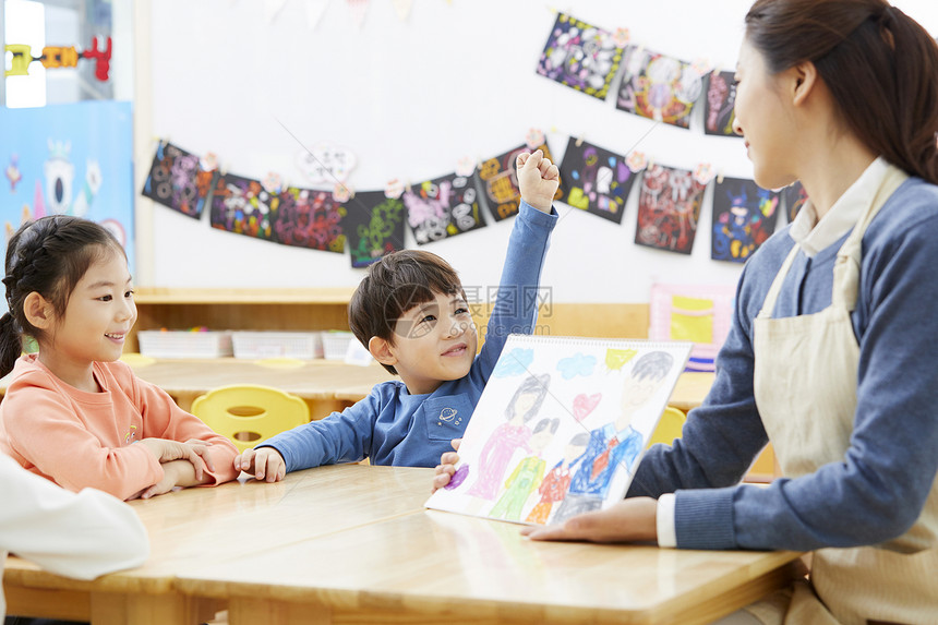 幼儿园的老师在带着学生们画画图片