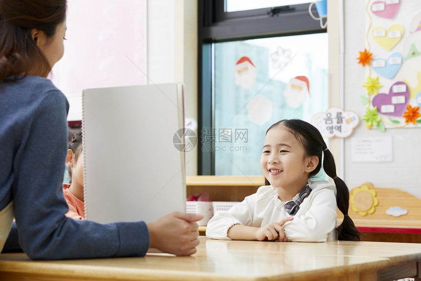 幼儿园的老师在带着学生们画画图片