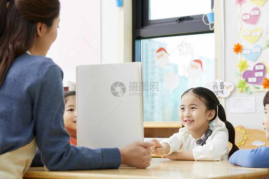 看幼儿园的老师在带着学生们画画图片