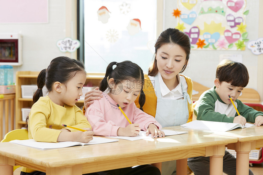 幼儿园的老师在带着学生们画画图片