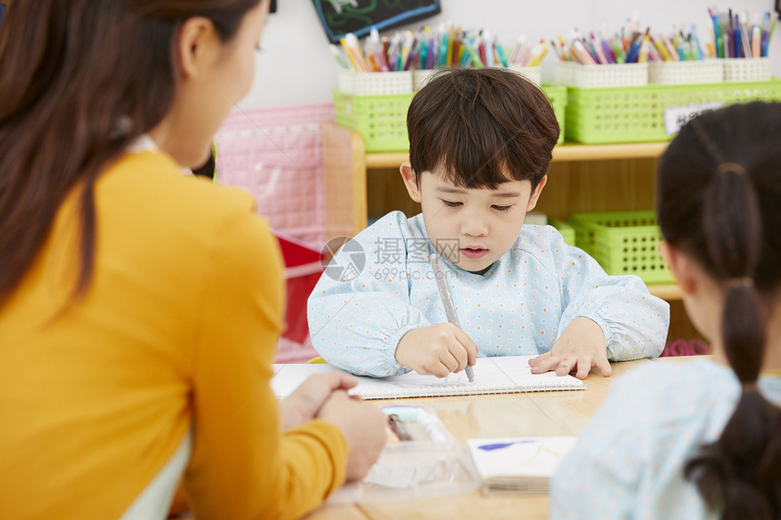 幼儿园的老师在带着学生们画画图片