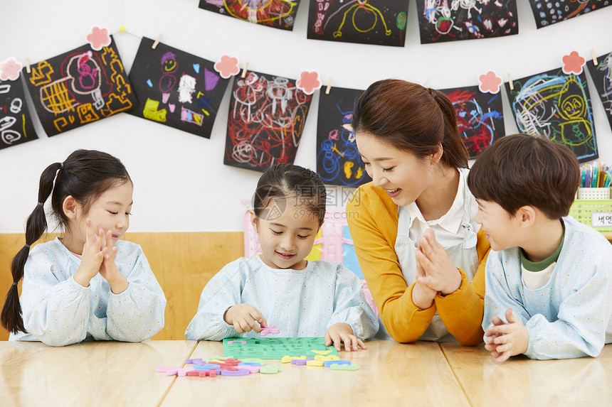 幼儿园的老师在带着学生们上课玩耍图片