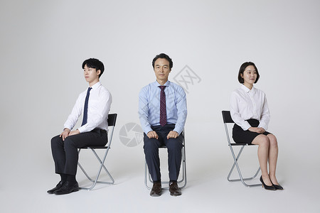 三人商务人士坐在椅子上图片