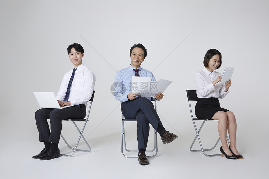 三人商务人士坐在椅子上图片