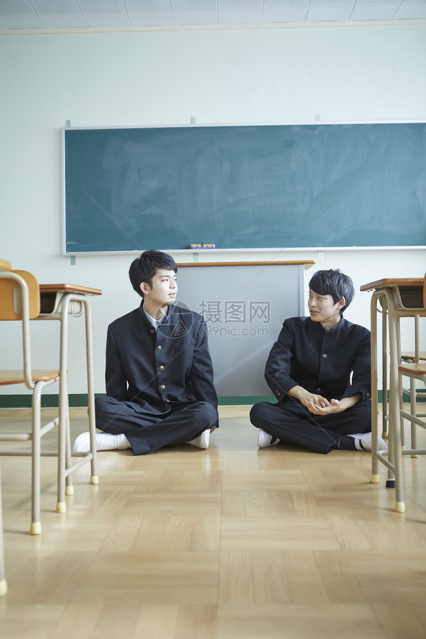 日式制服的男学生坐在教室地板上聊天图片