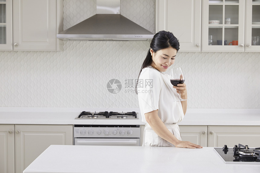 厨房里喝红酒的成年女子图片