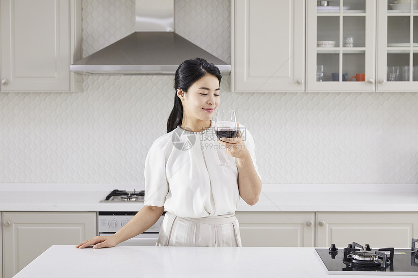 厨房里喝红酒的成年女子图片