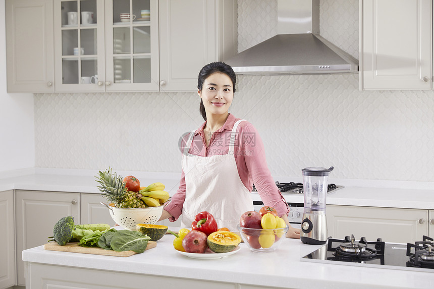 厨房里穿着围裙的年轻女子图片