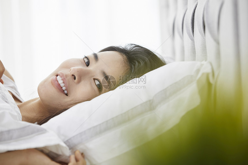 躺在床上休息的女青年图片