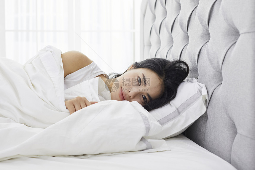 躺在床上休息的成年女子图片