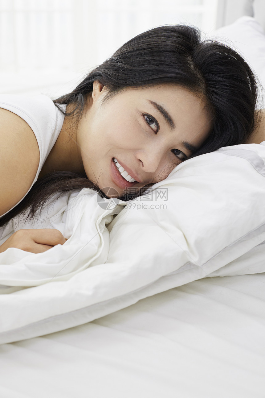 居家躺在床上休息的女青年图片