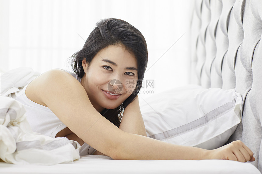 卧室里休息微笑的青年女性图片