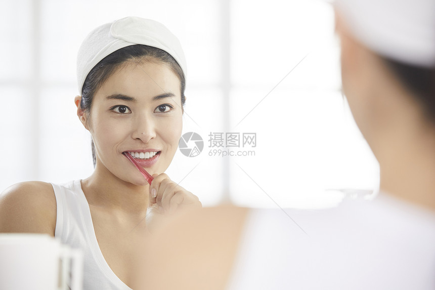 拿着牙刷刷牙的年轻女子图片